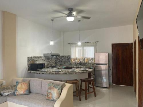 a living room with a couch and a kitchen at Villanueva Suite’s in Chacala