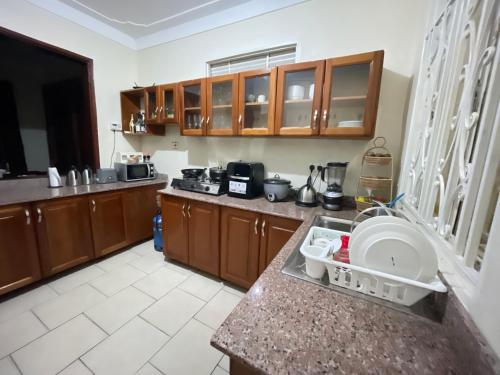 a kitchen with wooden cabinets and a counter top at Lake District Homestay in Rubirizi