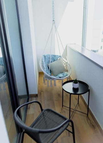 a room with a chair and a swing and a table at Vibrant Studio in Timişoara