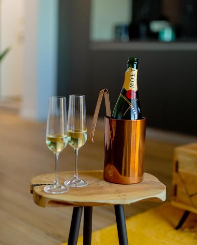 a bottle of champagne and two wine glasses on a table at Vibrant Studio in Timişoara