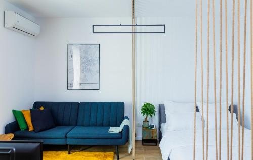 a living room with a blue couch and a bed at Vibrant Studio in Timişoara