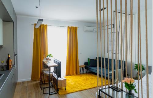 a living room with a blue couch and yellow curtains at Vibrant Studio in Timişoara
