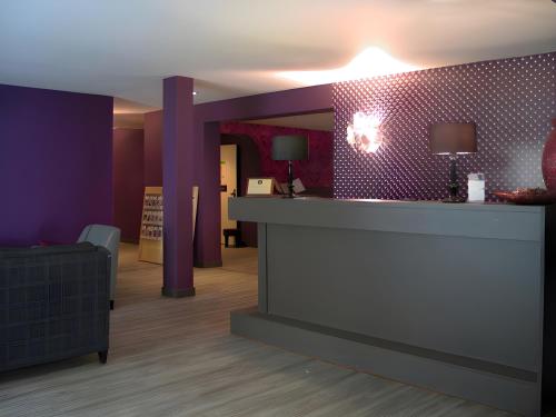 a lobby with a reception desk and purple walls at Hotel Myrtilles in Vielsalm