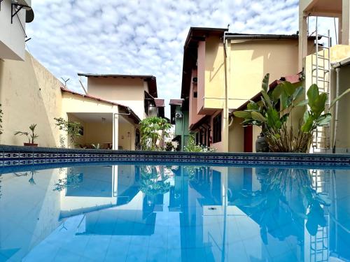 una piscina frente a unos edificios en La Condamine Apart Hotel, en Iquitos