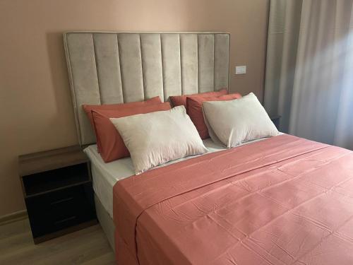 a bedroom with a large bed with pink sheets and pillows at Apparemment à côté du corniche au parc in Mohammedia