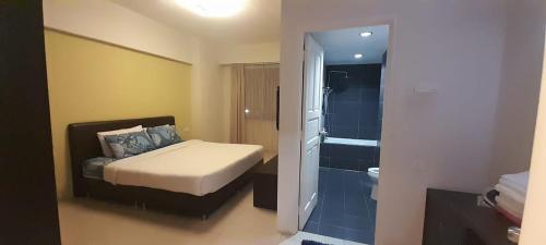ein Schlafzimmer mit einem Bett und ein Badezimmer mit einer Dusche in der Unterkunft K. Riverfront apartment in Ipoh
