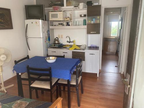 een keuken met een tafel en stoelen en een koelkast bij Apartamento cerca Playa Mansa y centro Maldonado aire acondicionado TV cable, Wifi Netflix in Maldonado