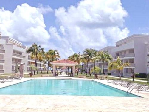 a swimming pool with a gazebo and palm trees at Come, Enjoy & Relax Bosque del Mar 1 Rio Grande, PR in Rio Grande