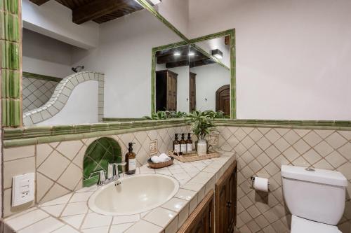 a bathroom with a sink and a toilet and a mirror at 3BR Garden Home with Rooftop & Garage in Centro San Miguel de Allende in San Miguel de Allende