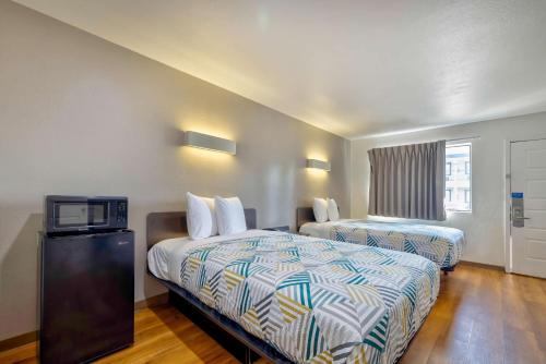 a hotel room with two beds and a tv at Motel 6-Bryan, TX - College Station in Bryan