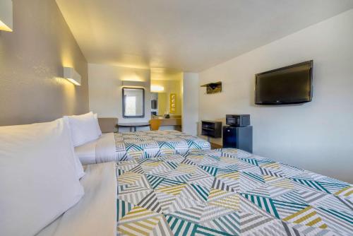a hotel room with a bed and a flat screen tv at Motel 6-Bryan, TX - College Station in Bryan