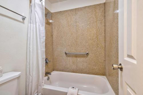 a bathroom with a white tub and a shower at Motel 6-Bryan, TX - College Station in Bryan