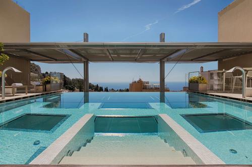 - une grande piscine au-dessus d'un bâtiment dans l'établissement NH Collection Taormina, à Taormine