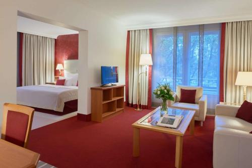 a hotel room with a bed and a living room at Dorint An den Westfalenhallen Dortmund in Dortmund