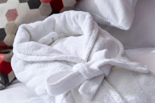 a white towel laying on top of a bed at Dorint An den Westfalenhallen Dortmund in Dortmund
