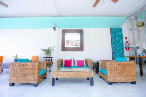 Habitación con sillas y mesa con almohadas de colores. en Pa´Xa Mama Hotel Boutique, en Cancún