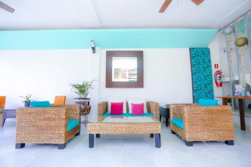 Una habitación con sillas y una mesa con almohadas de colores. en Pa´Xa Mama Hotel Boutique, en Cancún