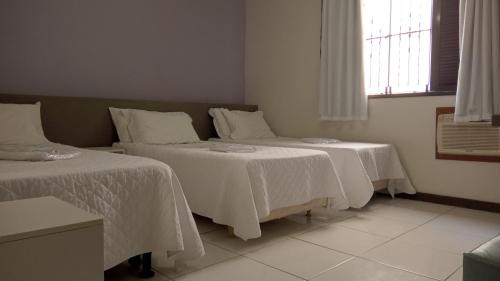 Un pat sau paturi într-o cameră la Pousada Colonial