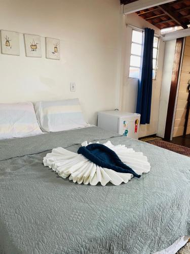 a bedroom with a large bed with a blue pillow on it at Quartinho Branco in Atins