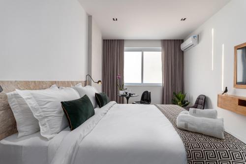 - une chambre dotée d'un grand lit blanc avec des oreillers verts et blancs dans l'établissement Unhotel - Rio Exclusive Design Loft Copacabana Perto da Praia, à Rio de Janeiro