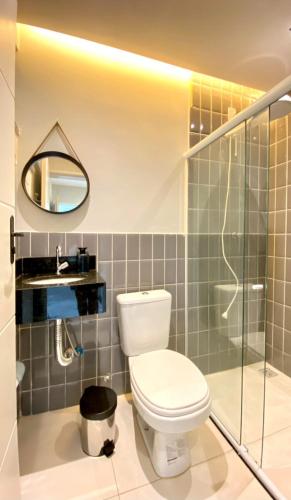 a bathroom with a toilet and a shower and a mirror at IM Suites in Macambira
