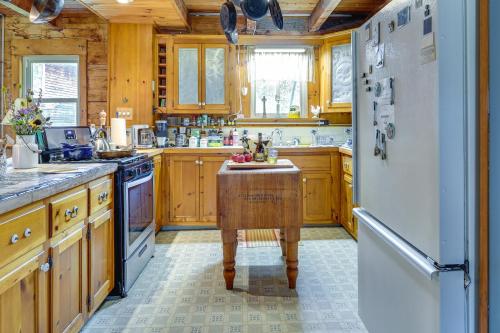 a kitchen with wooden cabinets and a white refrigerator at Cozy Adirondack Cabin Retreat in West Chazy! in West Chazy