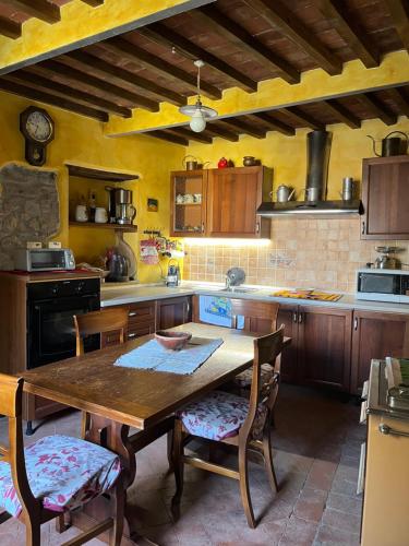 une grande cuisine avec une table et des chaises en bois dans l'établissement La Rocca Sovrana - Casa Vacanze, à Aramo