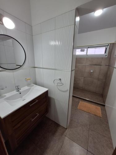 Un baño con lavabo y ducha con espejo. en CALA DEPARTAMENTO, en Alta Gracia