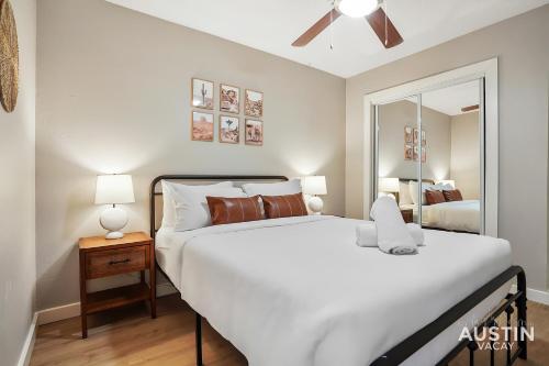 Un dormitorio con una gran cama blanca y un espejo. en Amenity Heavy Serene Apt in Convenient Location, en Austin