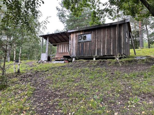 a wooden cabin in the middle of a field at koselig liten hytte i Skien in Skien