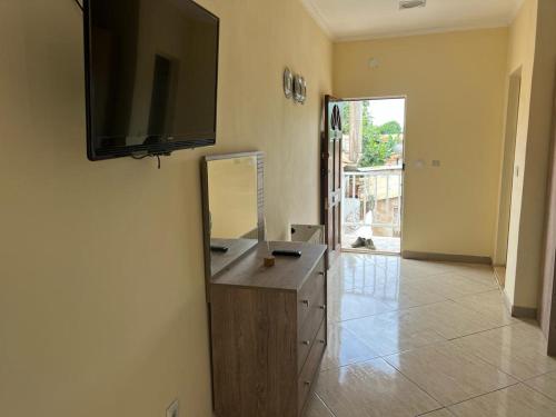 een kamer met een spiegel en een televisie aan de muur bij Guesthouse Celeste in São Tomé