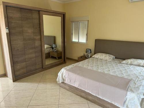 een slaapkamer met een bed en een grote spiegel bij Guesthouse Celeste in São Tomé