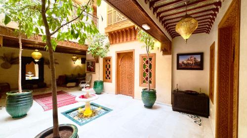 a living room with potted trees and a couch at Riad Diamond Of Marrakech in Marrakech