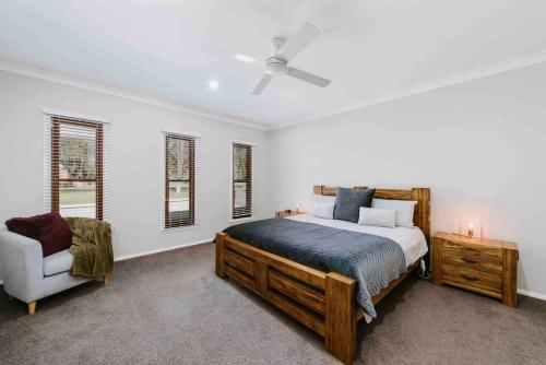 a bedroom with a bed and a chair at Dumplings Den in Mudgee