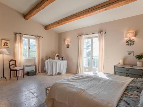 1 dormitorio con cama, mesa y ventanas en Villa Olivier, en Callian