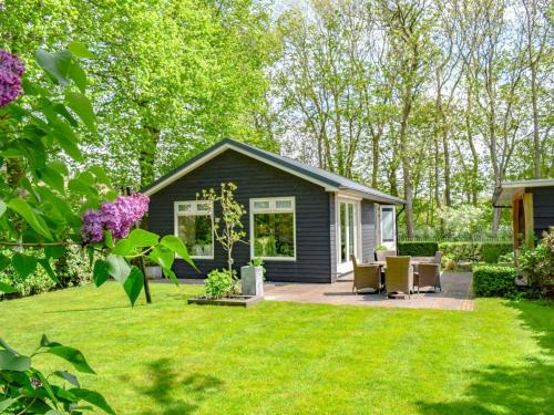 a small black house with a patio in a yard at De IJsvogel in Heiloo