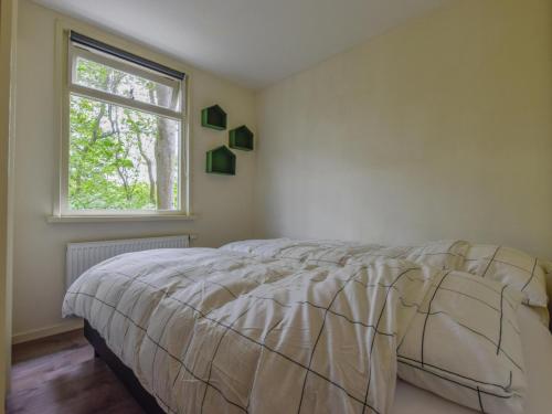 ein Schlafzimmer mit einem Bett und einem Fenster in der Unterkunft De IJsvogel in Heiloo