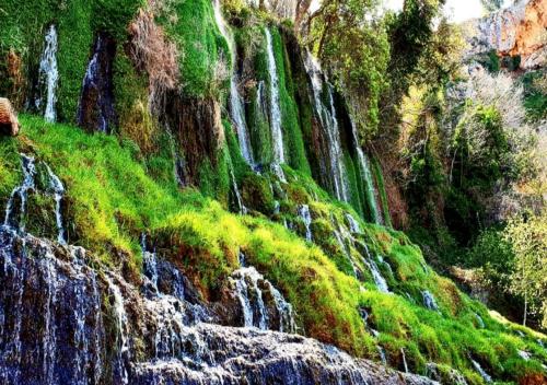 a group of waterfalls on a hill with grass at Villa Castro in Nuévalos