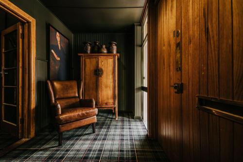 uma sala de estar com uma cadeira e um armário em The Amalfi Minimalist Room 604 em Hepburn Springs