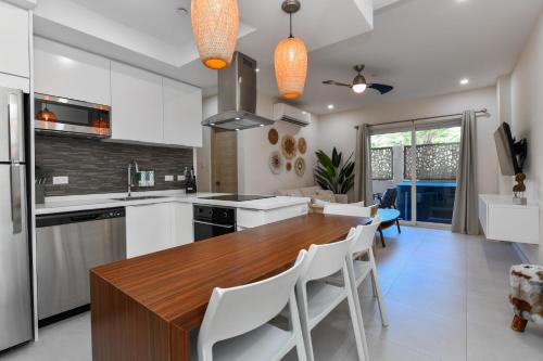 een keuken met een houten tafel en witte apparaten bij Aracari 1 in Palm-Eagle Beach