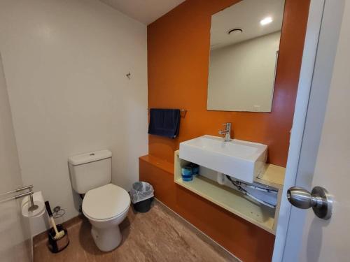 een badkamer met een wit toilet en een wastafel bij Empire Apartments in Auckland