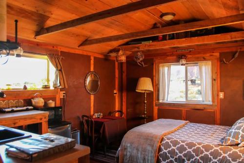 a bedroom with a bed and a desk and windows at Rustic Ranch Getaway Near Zion, Bryce, Grand Canyon in Fredonia