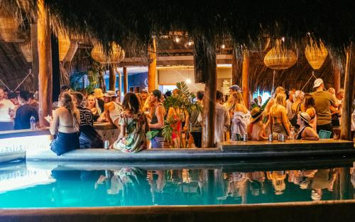 a group of people sitting around a swimming pool at the SPACE. in San Juan del Sur