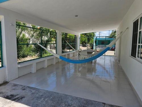 a room with a hammock on a porch at La Casita de Chelem in Chelem