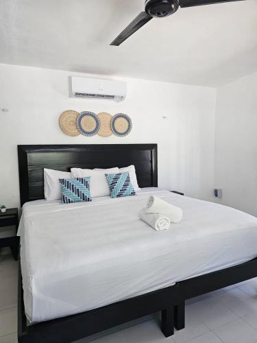 a bedroom with a large bed with two towels on it at La Casita de Chelem in Chelem