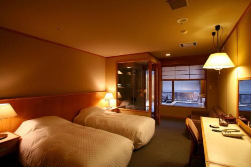 千歳市にある支笏湖第一寶亭留翠山亭のベッド2台とテレビが備わるホテルルームです。