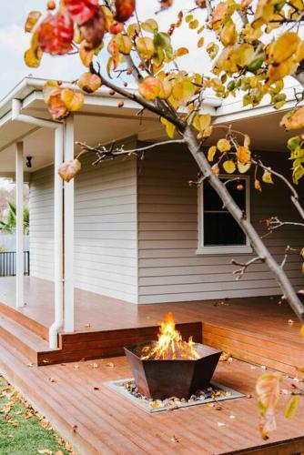 a fire pit on a deck in front of a house at Dumplings Den in Mudgee