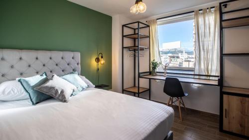 a bedroom with a bed and a desk and a window at 103 Wonderful House in Bogotá