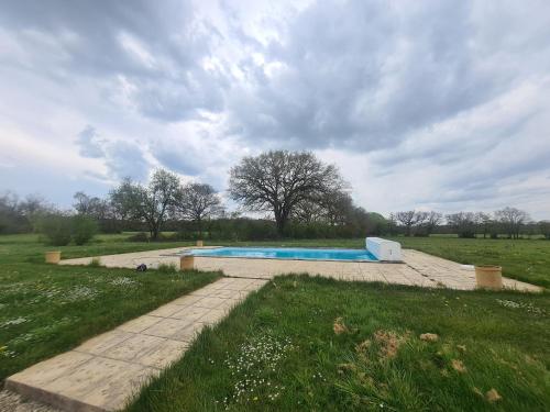 une piscine au milieu d'un champ dans l'établissement Maison de vacances avec piscine partagée dans le Parc de la Brenne, linge et ménage inclus - FR-1-591-199, à Bélâbre