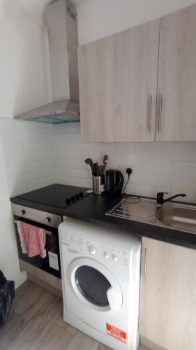 a kitchen with a washing machine in a kitchen at Flat 6 in Croydon